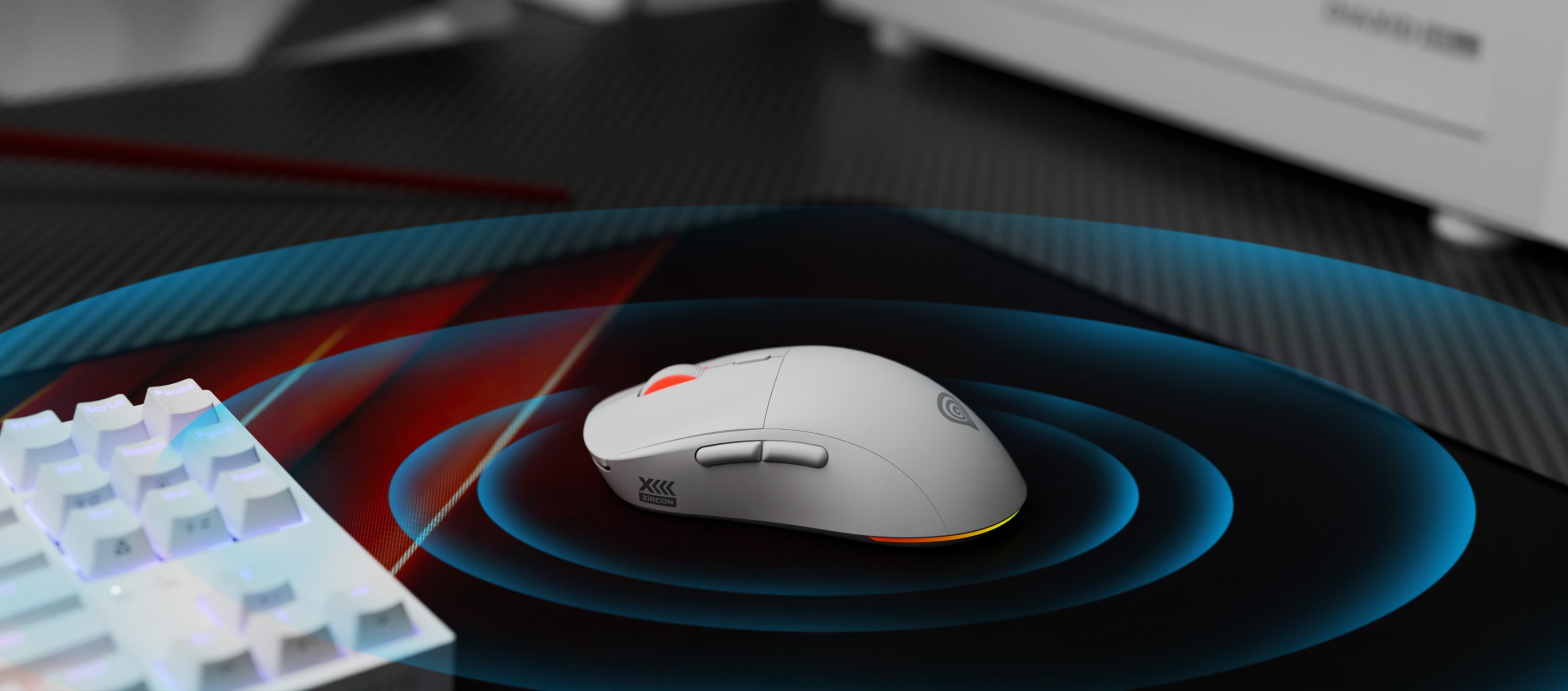 Ratón inalámbrico para juegos Genesis Zircon XIII con funciones personalizables y 26000 PPP, colocado sobre una alfombrilla para juegos