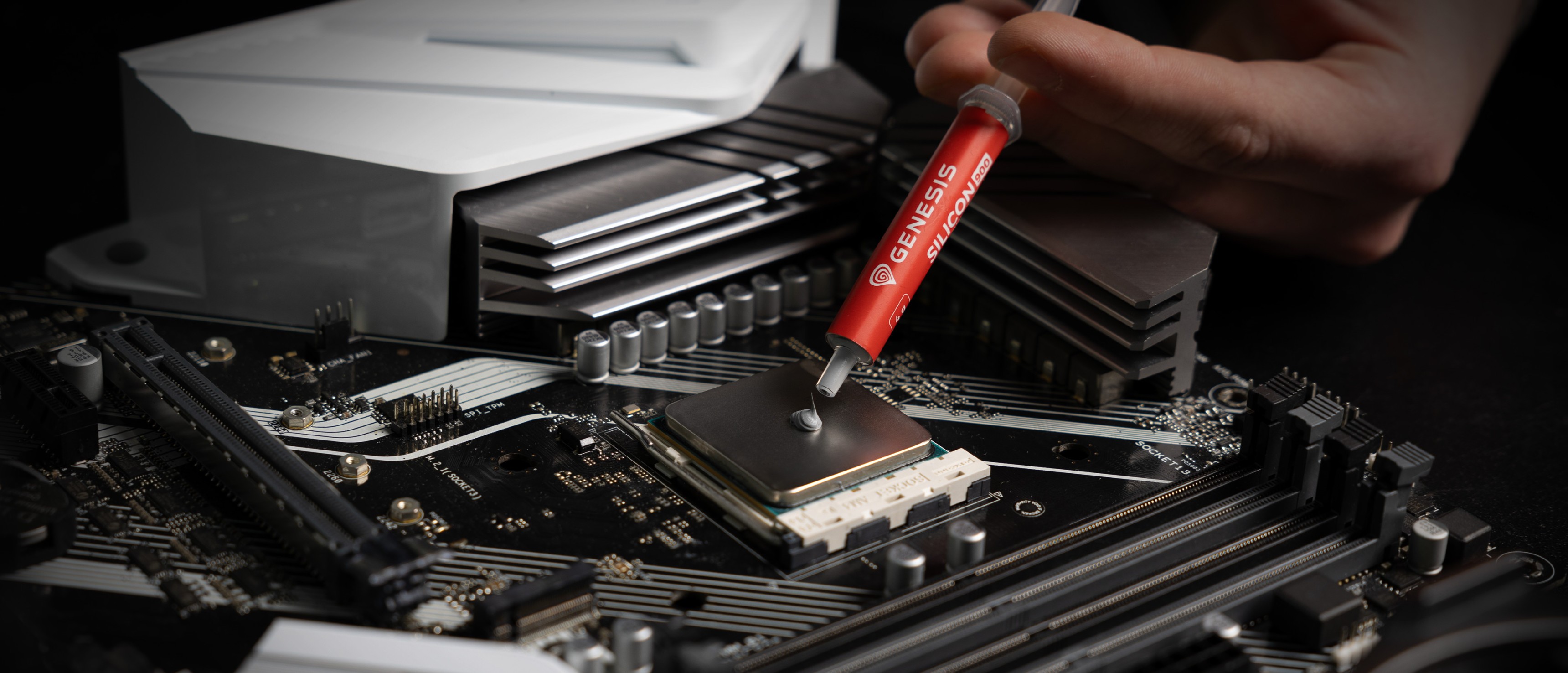 Aplicación de pasta térmica Genesis Silicon 900 en el zócalo de la CPU de una placa base para mejorar la conductividad térmica