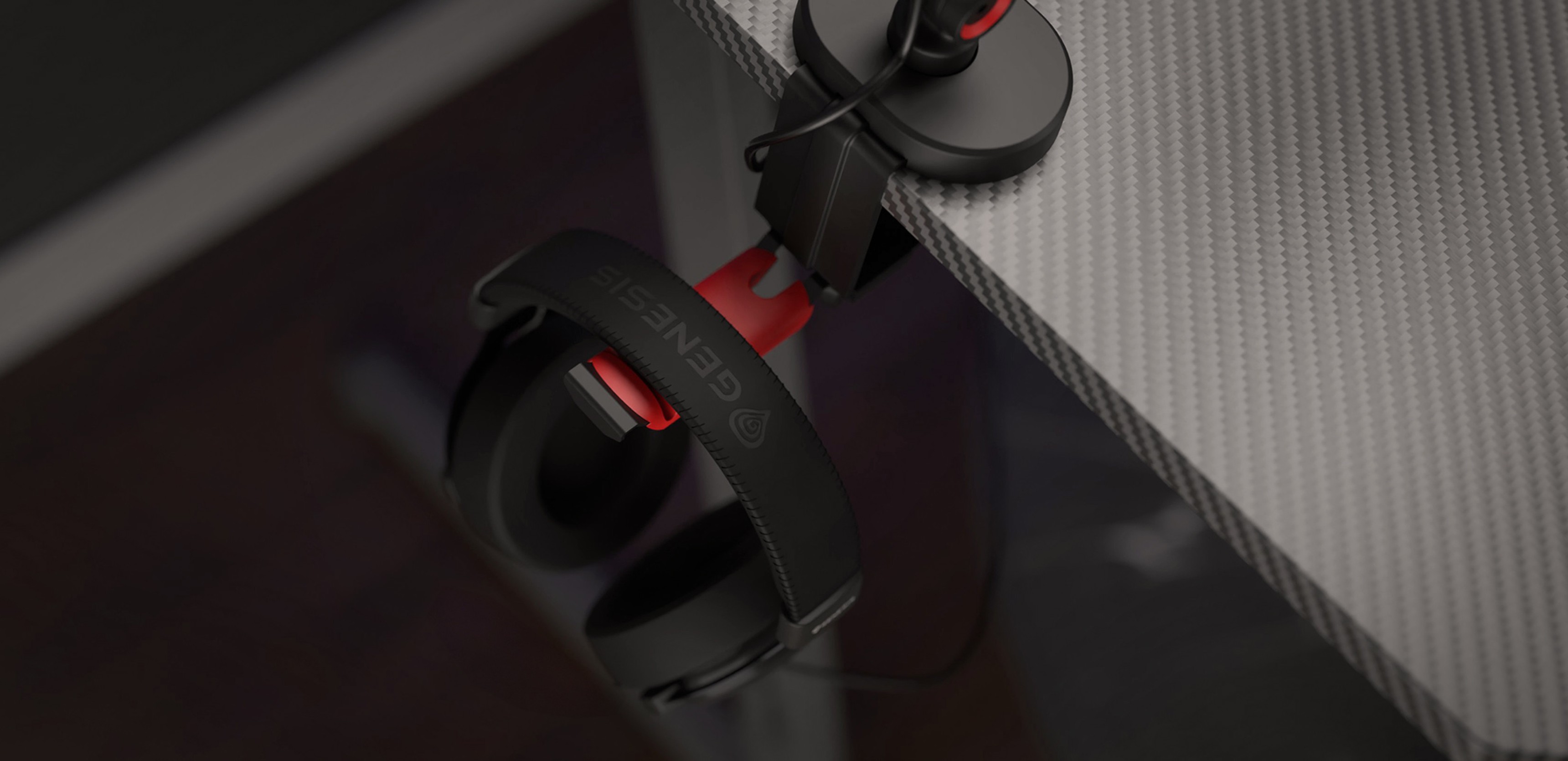 Brazo de micrófono con una percha para auriculares, mostrando unos auriculares con acentos rojos sujetos al borde de un escritorio