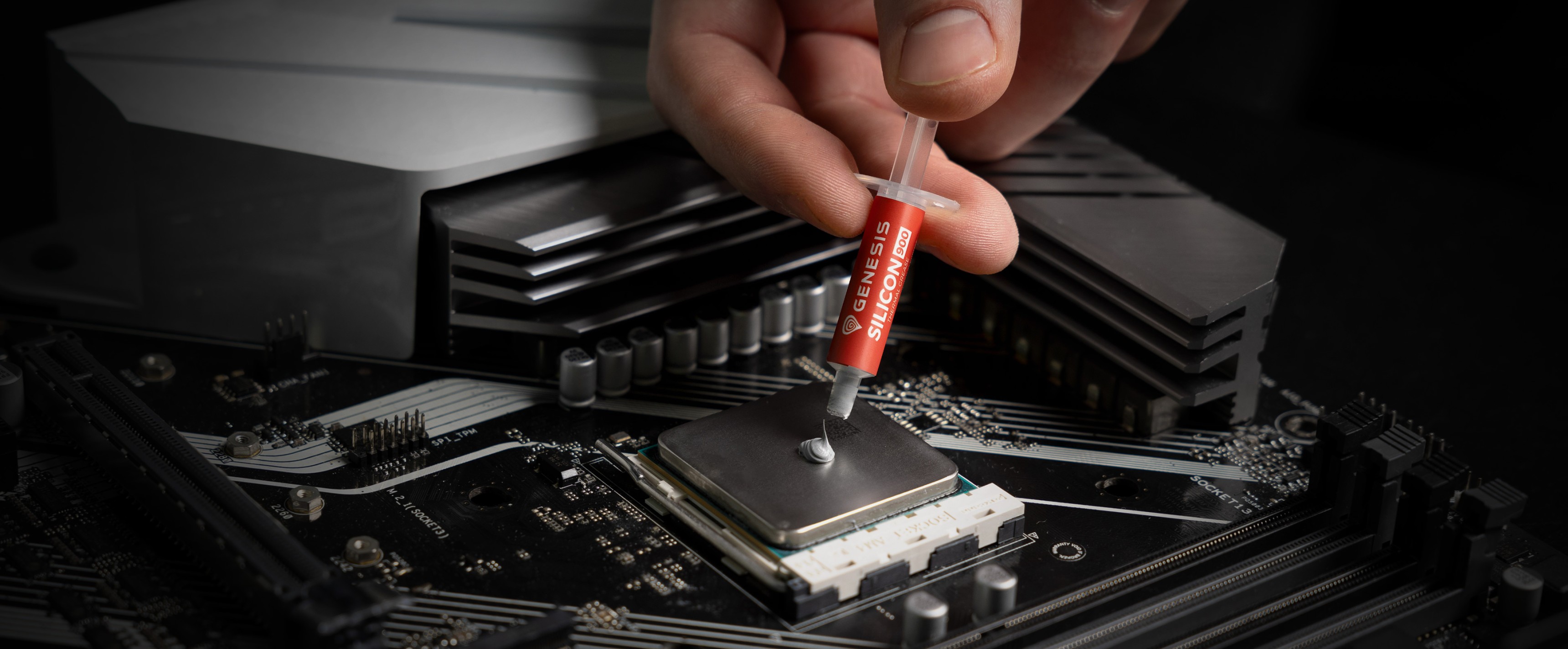 Aplicando a mano pasta térmica con una jeringuilla a una CPU en la configuración de una placa base de ordenador