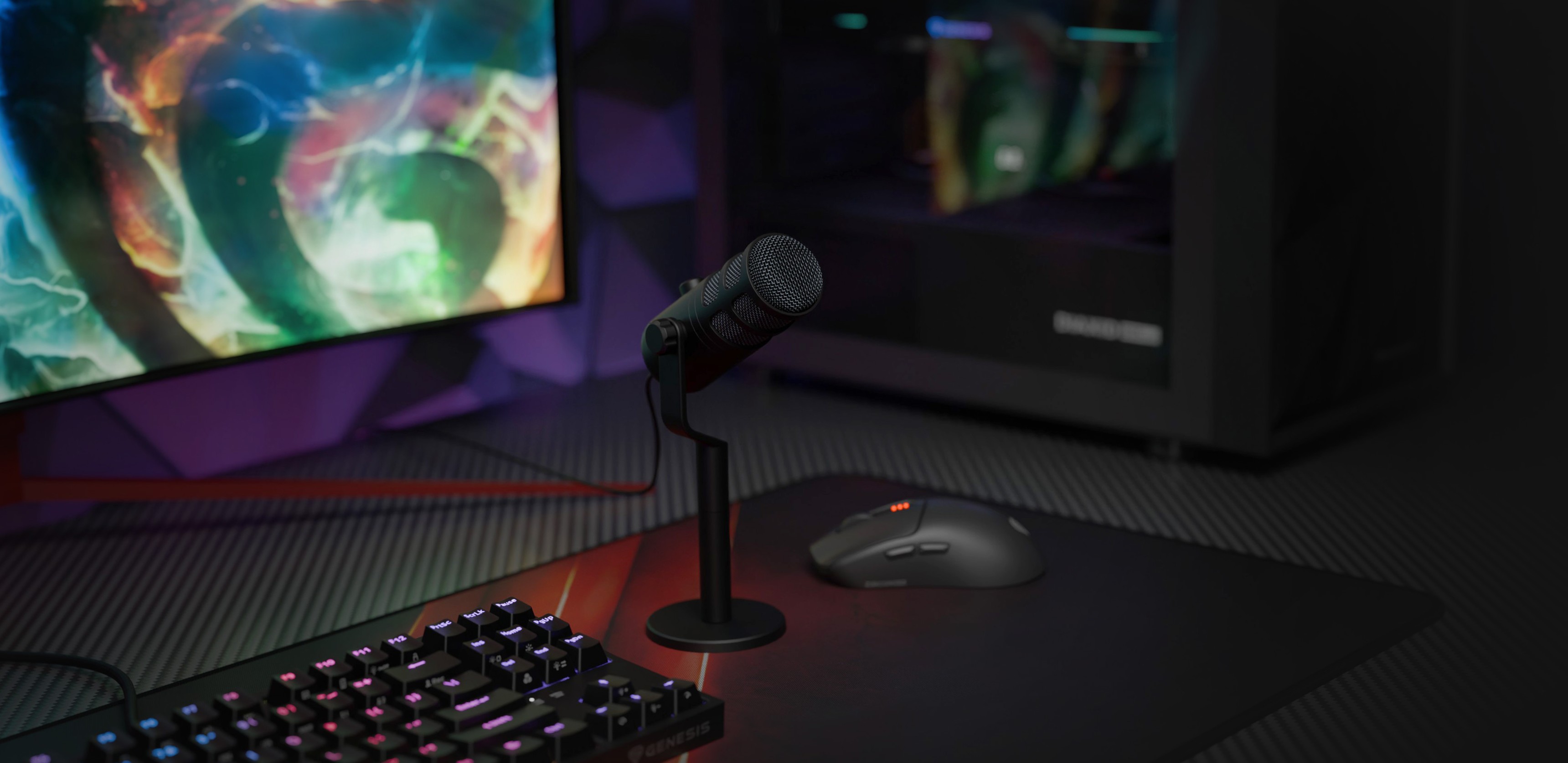 Micrófono dinámico USB en un soporte con un teclado y un ratón, sobre un colorido fondo de monitor de juegos