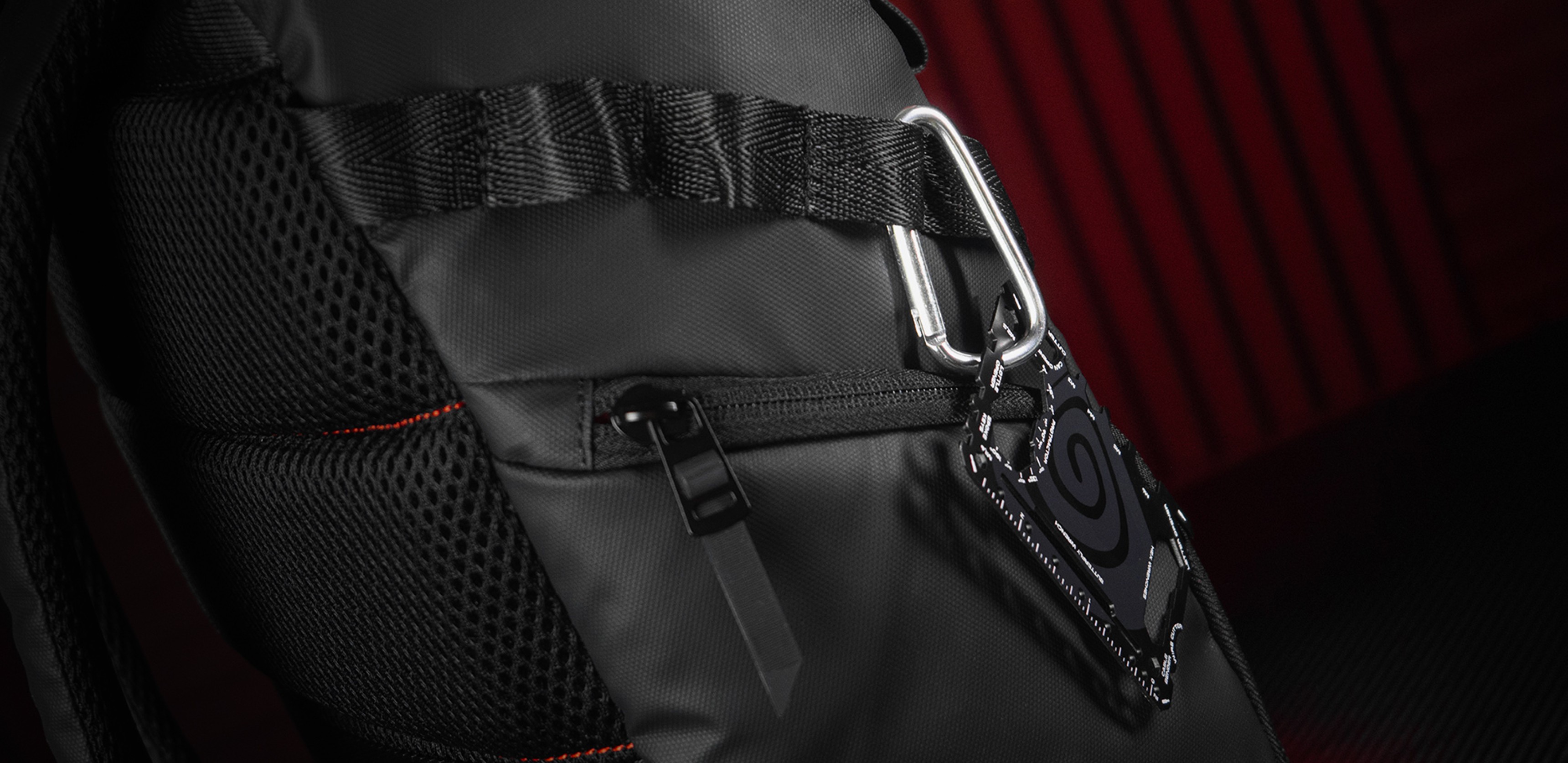 Mochila negra para portátil con detalles de malla y un clip en el lateral, diseñada para portátiles de 15,6", tiene 18 L de capacidad